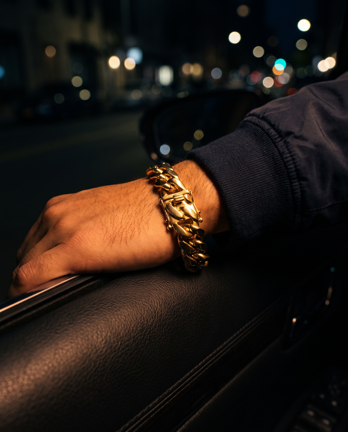 The Gilt Cuban Bracelet worn on wrist, car door, night city