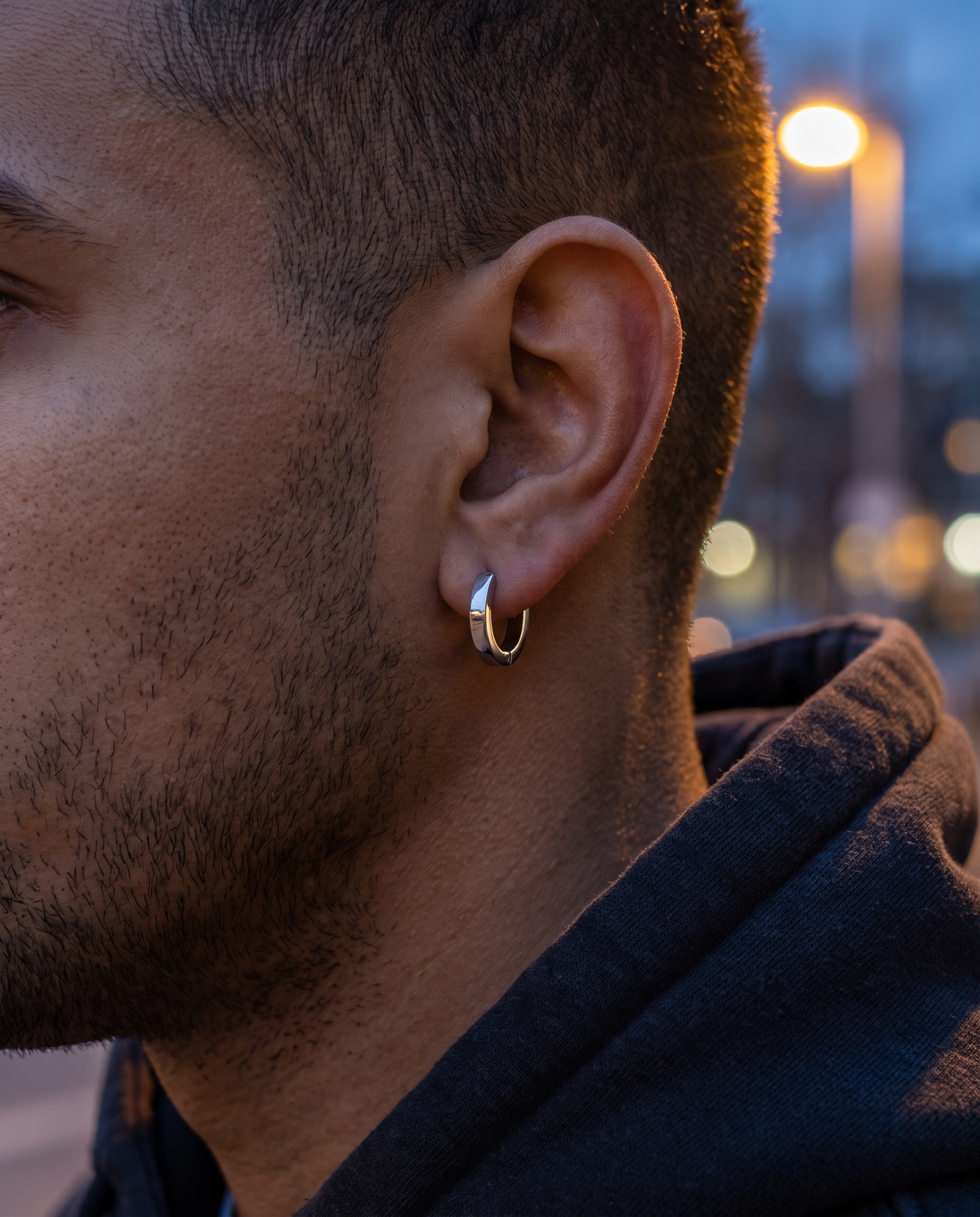 The Nova Huggie Hoops worn on ear, hoodie, night street